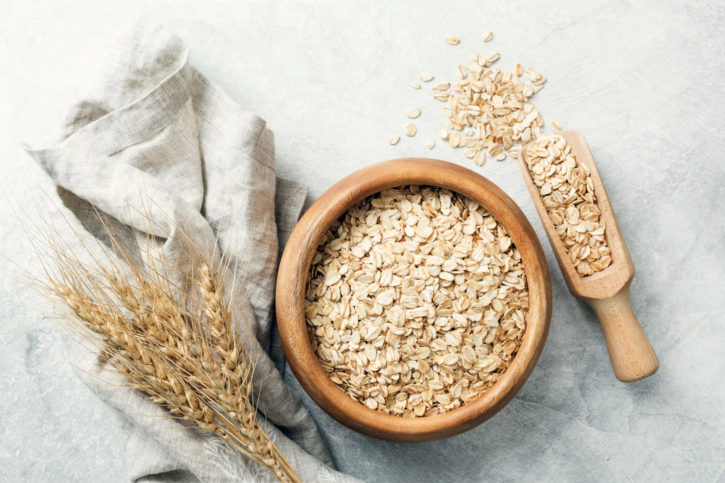 Rolled oats in wooden bowl and ears of wheat